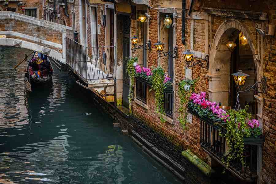Venice canal scene with gondola, lanterns, and flower boxes